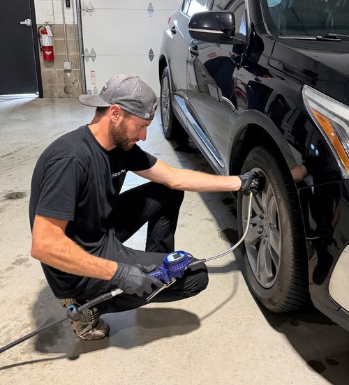 Nick Tizzano setting tire pressure on a customer vehicle at Tizzano Automotive in Plain City, OH
